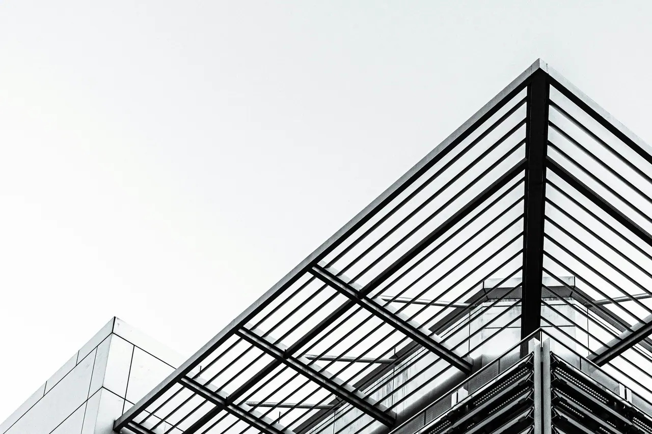 Steel roof structure against a pale sky