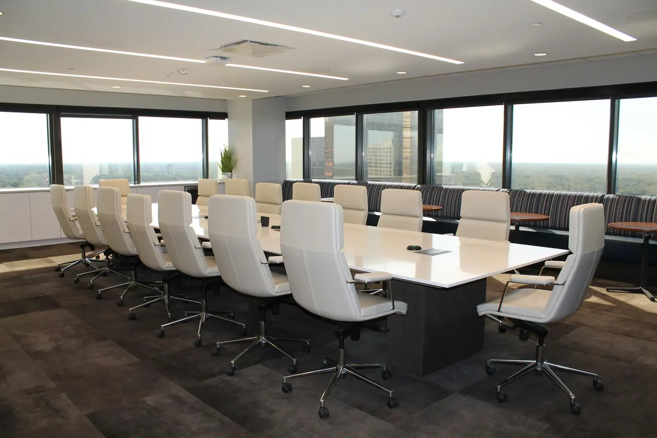 Empty boardroom with long table and white chairs